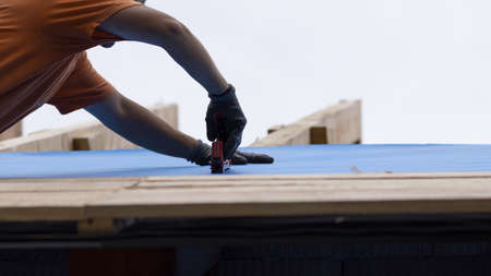 The worker holds the insulation layer with a stapler.の写真素材