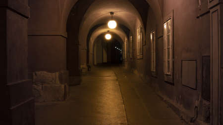 Night photo of an old and dark alley in the arcade.の写真素材