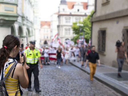 Young woman journalist is waiting for the right moment to take a photo of the protest.