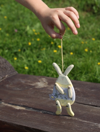 Children hand leads toy rabbitの写真素材