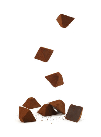 Falling chocolate truffles on a white background の写真素材