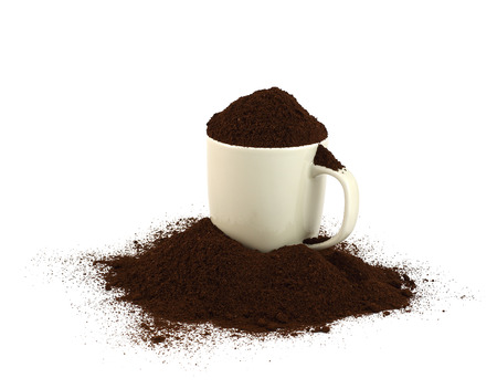 A cup of ground coffee with many of them spread around  White background の写真素材