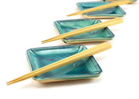 An empty sushi plates with chopsticks isolated on white background の写真素材