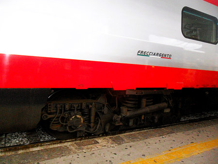 The train, characterized by its distinctive white, red, and silver livery, is depicted both...
