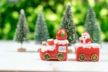 Santa sitting on santas train running pass Christmas tree forest to send happiness to all on...