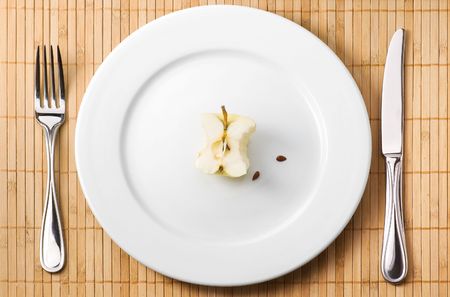 Apple bit on the plate with fork and knifeの写真素材