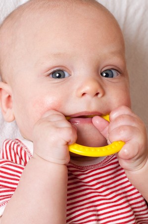 Cute baby with a yellow teething ring