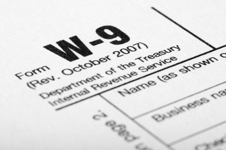 Closeup of female hand filling out W-9 income tax form with penの写真素材