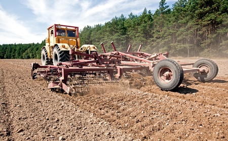 Harrowing a field with a diesel tractorの写真素材