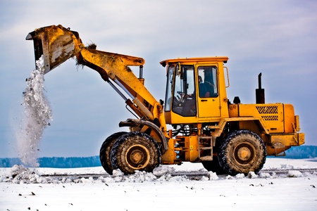 Wheel loader machine removing snow in winter from the roadの写真素材