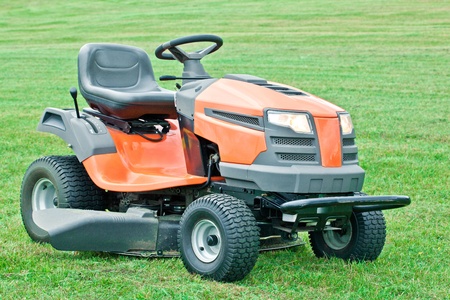 Lawn mower with the lights on against on green grass backgroundの写真素材