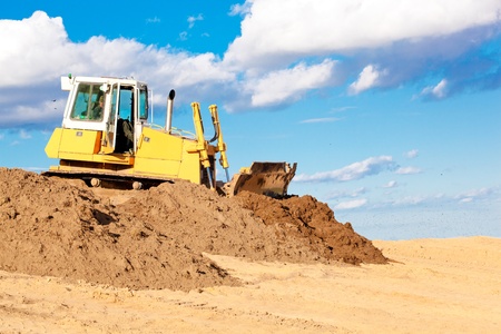 Bulldozer machine moving soil at construction site during earth moving worksの写真素材
