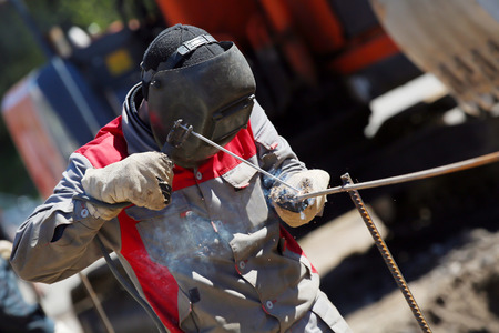 Welder worker welding steel rod rebar outdoorsの写真素材