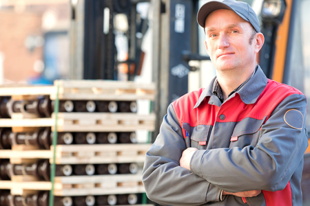 Industrial worker on forklift truck with factory finished goods backgroundの写真素材