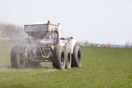 Farmer fertilizing winter crops landの写真素材
