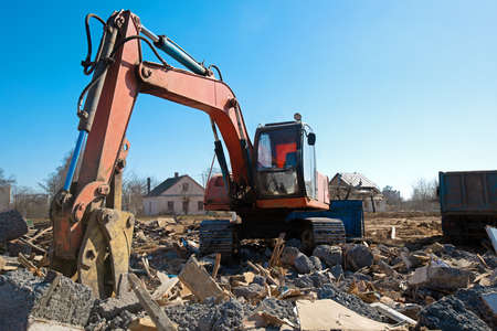 Demolition works. Excavator broken houses at construction site during rebuilding construction jobsの写真素材