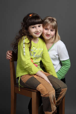portrait of two sisters European appearance gray backgroundの写真素材