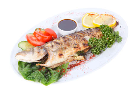 fried grilled fish on a plate isolated on white backgroundの写真素材