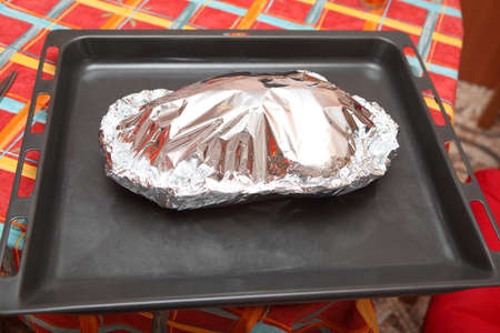 duck baked with apples and oranges in foilの写真素材