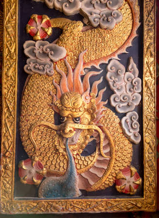 Dragon sculpture holding ball on winfow panel of Chinese templeのeditorial素材