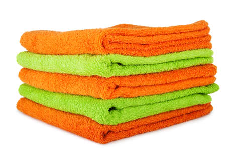 A stack of multicolored orange and green towels on the white backgroundの写真素材