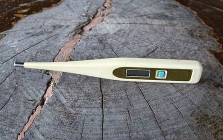 Digital thermometers on wood background