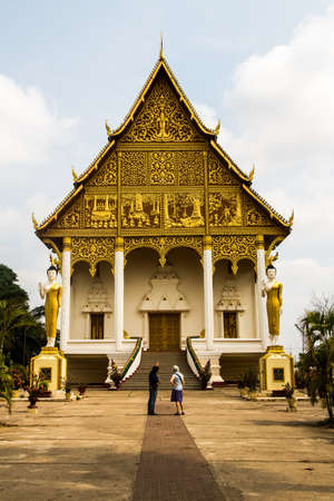 A tour guide explaining the story of Wat That Luang Neua temple to the tourist, Vientiane, Laosの写真素材