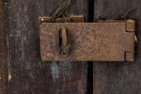 Closeup of old rusty door hinge on wooden doorの写真素材