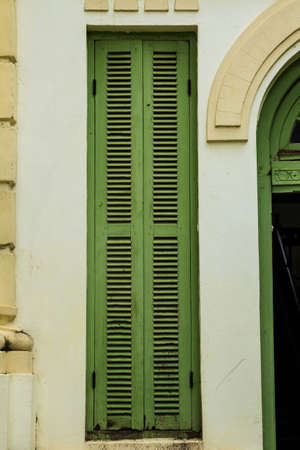 Green vintage wooden windows, colonial style building from Vientiane, Laos の写真素材