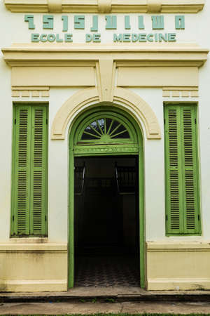 Green vintage wooden windows and door on yellow wall, colonial style building from Vientiane, Laos の写真素材