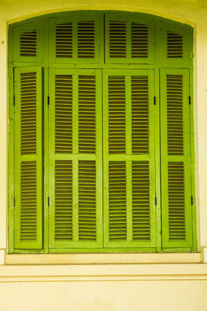 Green vintage wooden windows, colonial style building from Vientiane, Laos の写真素材