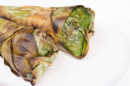 Sticky rice roast , wrapped in banana leaves and white background.の写真素材