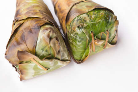 Sticky rice roast , wrapped in banana leaves and white background.の写真素材