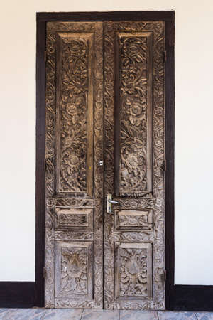 Vintage wooden door on white cement wallの写真素材