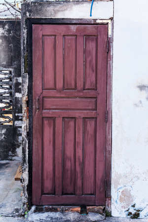 Old red door on the white buildingの写真素材