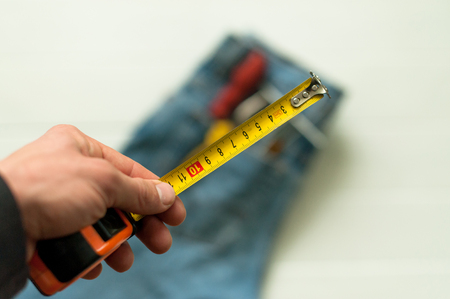 Measuring tool. Hand with a tape measure isolated on white backgroundの写真素材