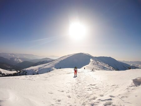 Road through deep snow. Beautiful sunny day with deep blue sky at a mountains with lot of snow all over the placeの写真素材