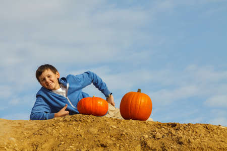 A boy with two pumkins on blue skyの写真素材