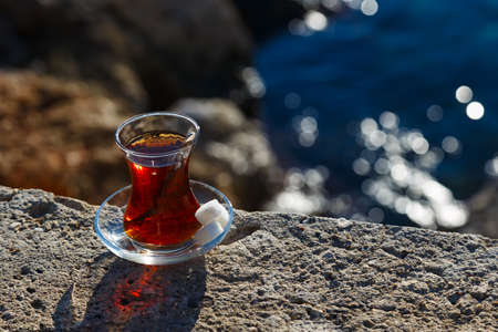 Turkish tea on a stone at seasideの写真素材