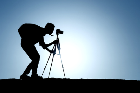 A silhouette of a photographer with a tripodの写真素材
