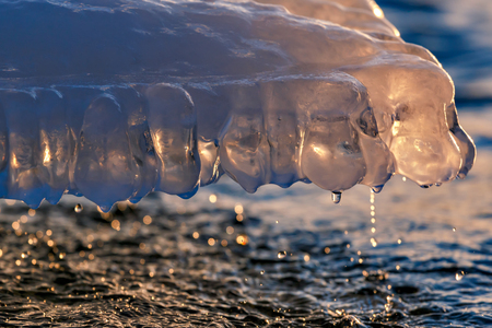 Icicle at sunset with drops of waterの写真素材