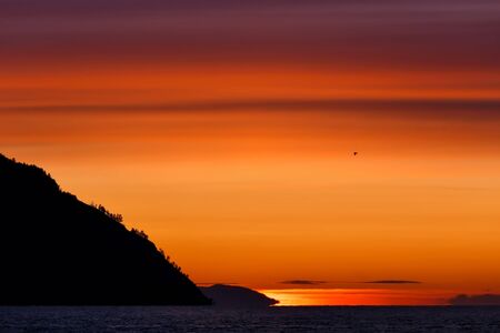 Colorful sunrise at Baikal lake with flying birdの写真素材
