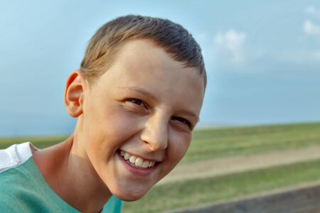 Teenager boy smiling widely in nature enviromentの写真素材