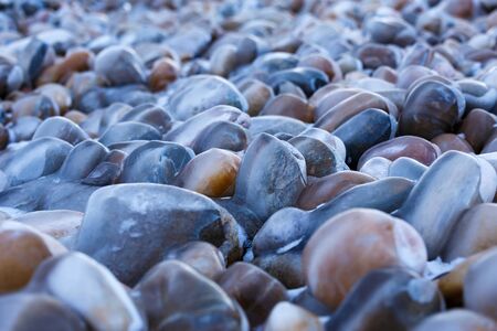 Colorful pebbles stone covered with ice on the shore of Baikal lake