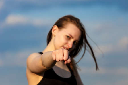 Soft focus of young woman smiling and showing fist in sport wearの写真素材