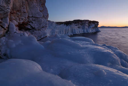 Baikal rocky shore covered with ice at sunsetの写真素材