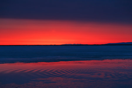 Sunrise at Baikal lake with water, ice and orange blue skyの写真素材