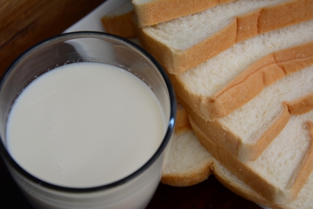 glass of milk with a dish full of bread  の写真素材