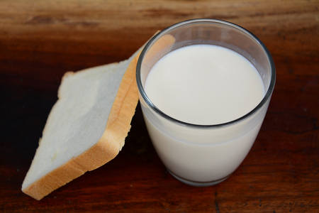 glass of milk with a dish full of bread  の写真素材