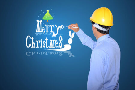 Engineers hands with tablet and Christmas Greeting Card  Merry Christmas lettering  の写真素材